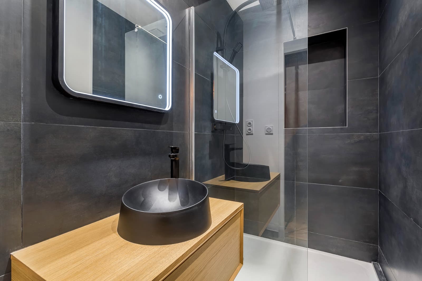 Vasque à poser noire mate et mitigeur noir sur meuble chêne suspendu, miroir rétroéclairé LED et douche en faïence anthracite à Bourg-Saint-Maurice